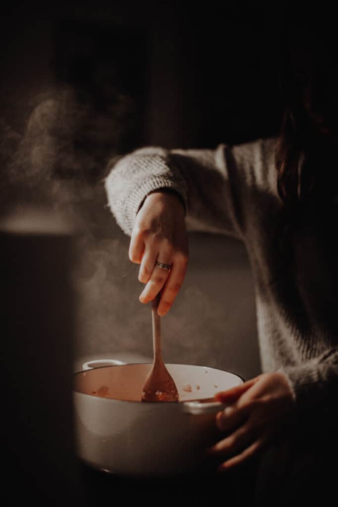 Stirring a pot over the stove.