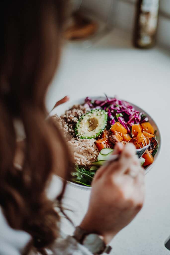 Over the shoulder shot of girl eating Sweet Potato Nourish Bowl - Vegan, Gluten-Free & Healthy! Georgie Eats.
