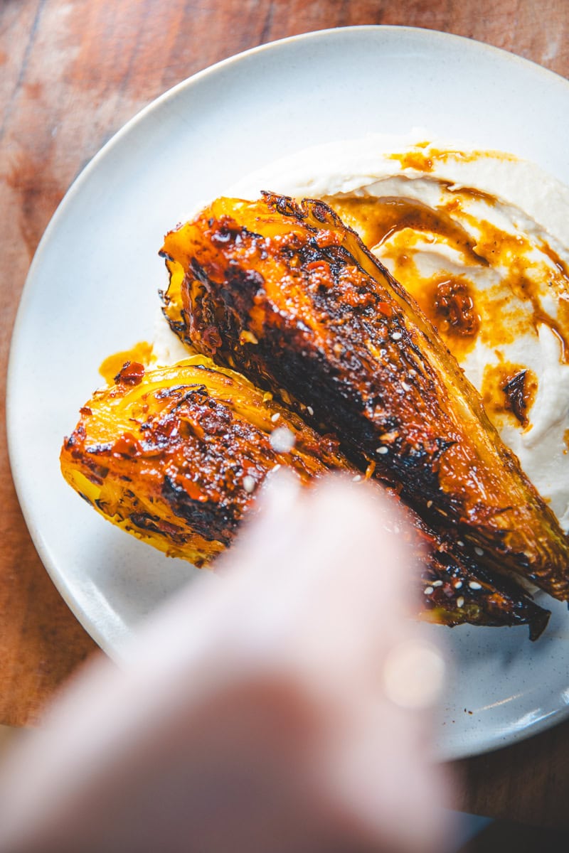 Plating the Harissa Hispi Cabbage & Butter Bean Mash - Georgie Eats